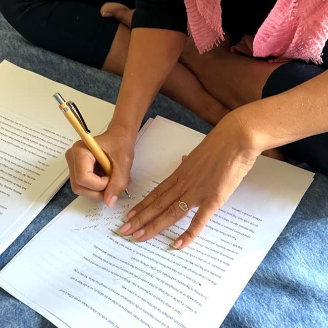 Lisa Weinert annotating a manuscript by hand, with the words A New Paradigm visible on the page